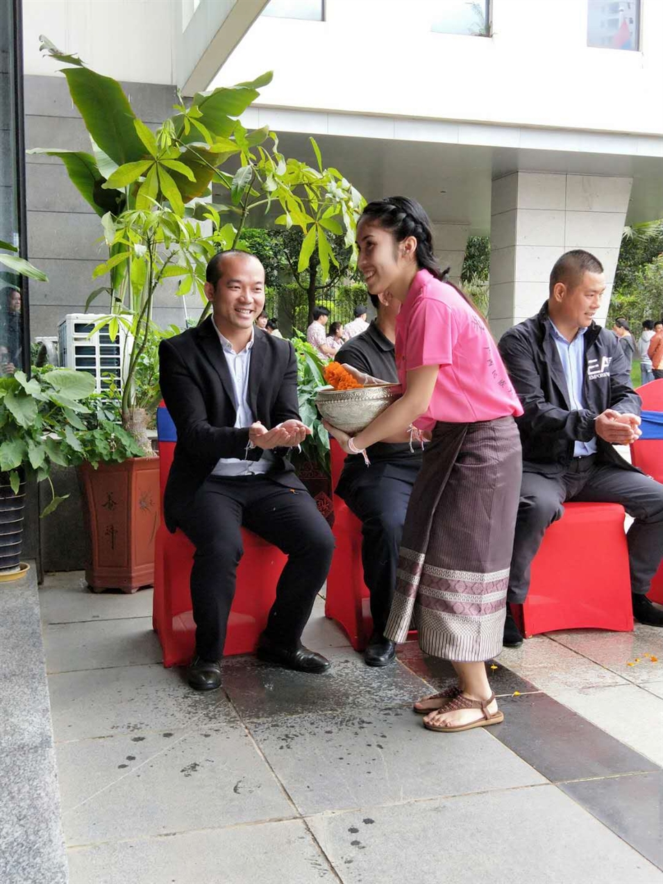 老撾駐廣西留學(xué)生代表將浸有花瓣的香水灑客人的手上，表示對(duì)嘉賓的美好祝福（圖一）